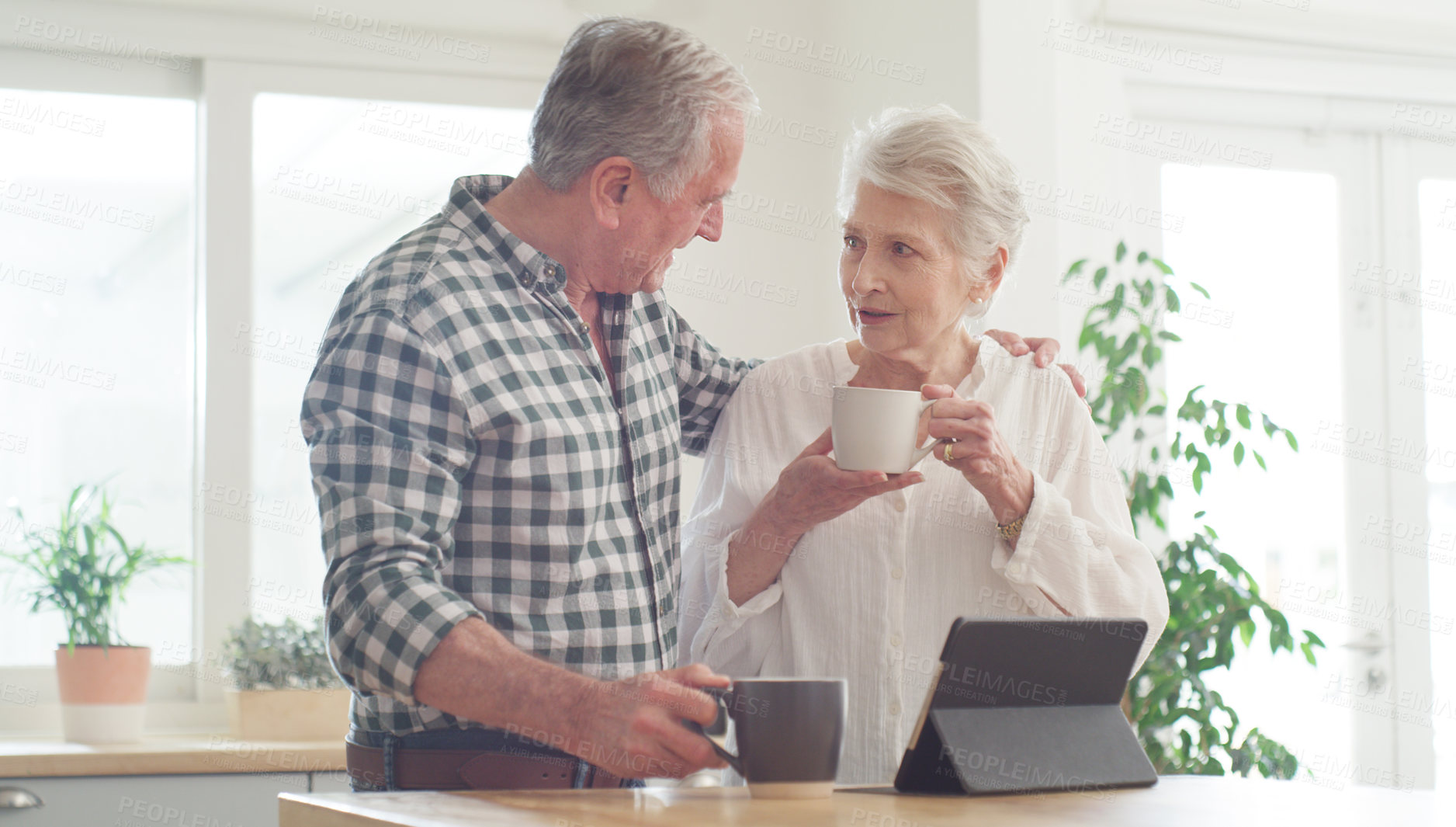 Buy stock photo Shot of a senior couple using a digital tablet at home