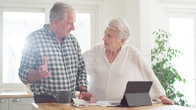 Buy stock photo Cropped shot of a senior couple using a digital tablet while going through paperwork at home