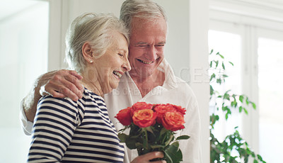 Buy stock photo Cropped shot of a senior man spoiling his wife with roses at home