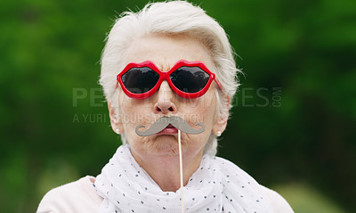Buy stock photo Portrait of a senior woman wearing fun glasses at the park