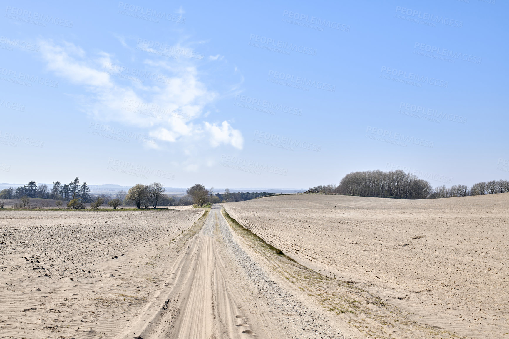 Buy stock photo Sandy landscape of a road in the desert sand on a hot summer day with a blue sky background. Dry remote land with a path outdoors in nature on a sunny afternoon. Dunes in an arid environment