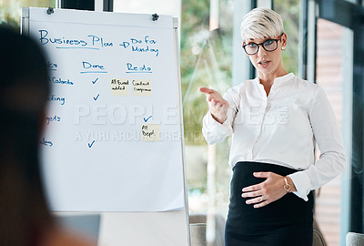 Buy stock photo Shot of a pregnant businesswoman using a whiteboard while giving a presentation in an office