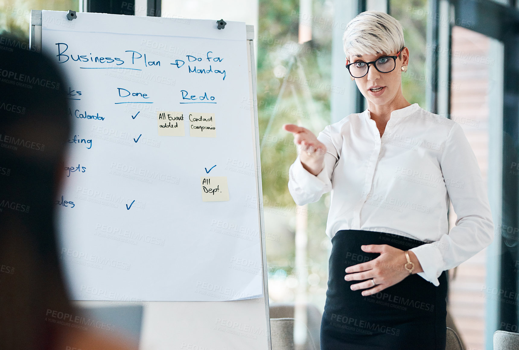 Buy stock photo Shot of a pregnant businesswoman using a whiteboard while giving a presentation in an office