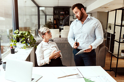 Buy stock photo Shot of two businesspeople having a discussion in an office