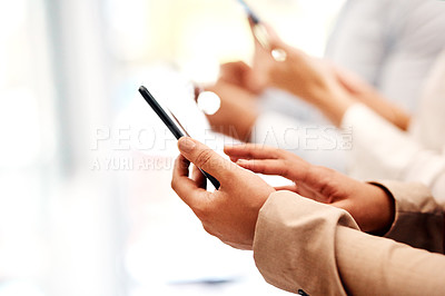 Buy stock photo Closeup shot of an unrecognisable businesswoman using a cellphone with her colleague in the background