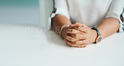 Buy stock photo Closeup shot of an unrecognisable businesswoman sitting with her hands clasped in an office