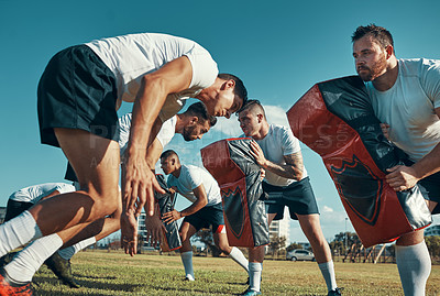 Buy stock photo Shot of a group of rugby players training with tackle bags on the field