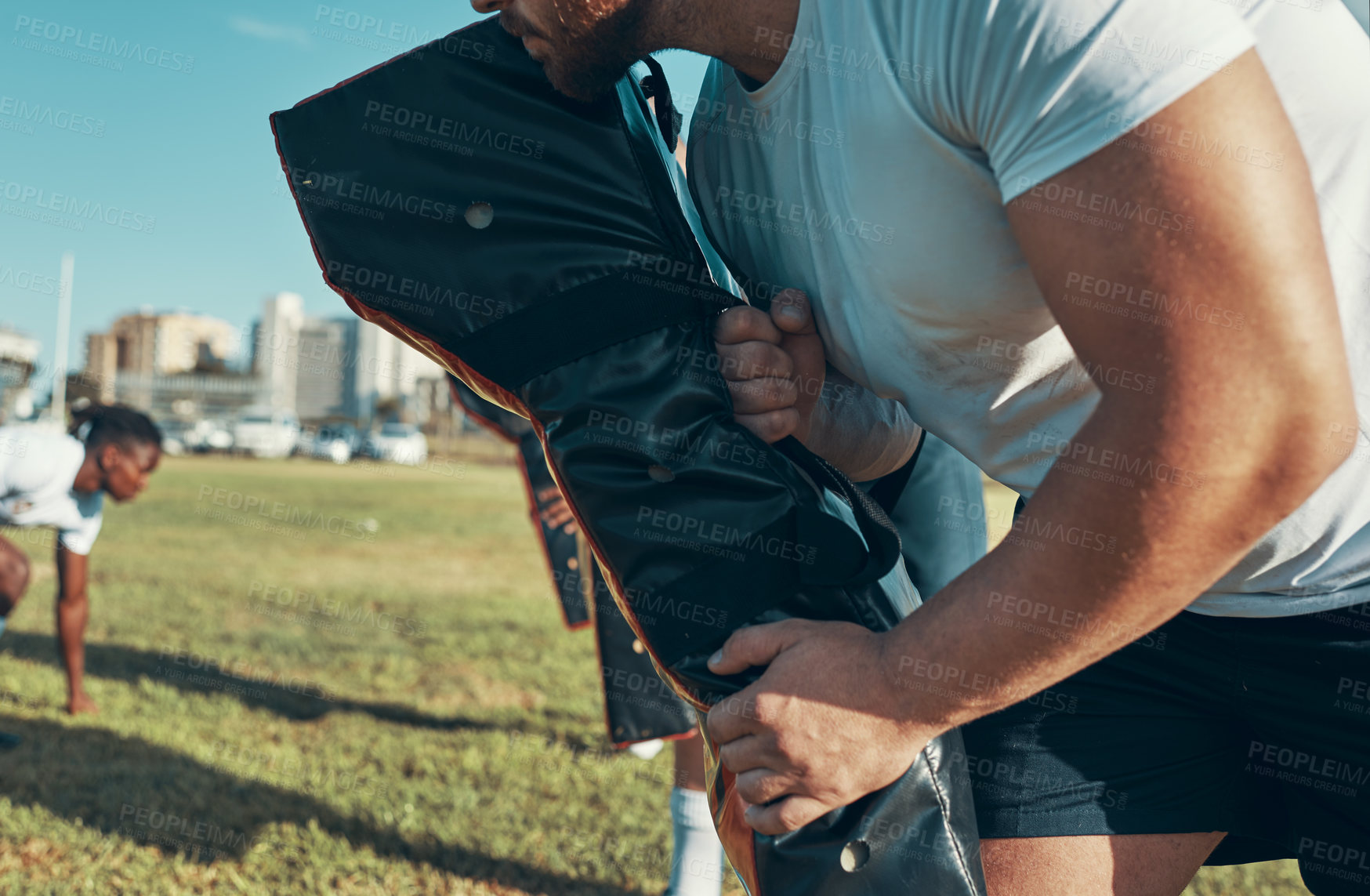 Buy stock photo Shot of rugby players training with tackle bags on the field