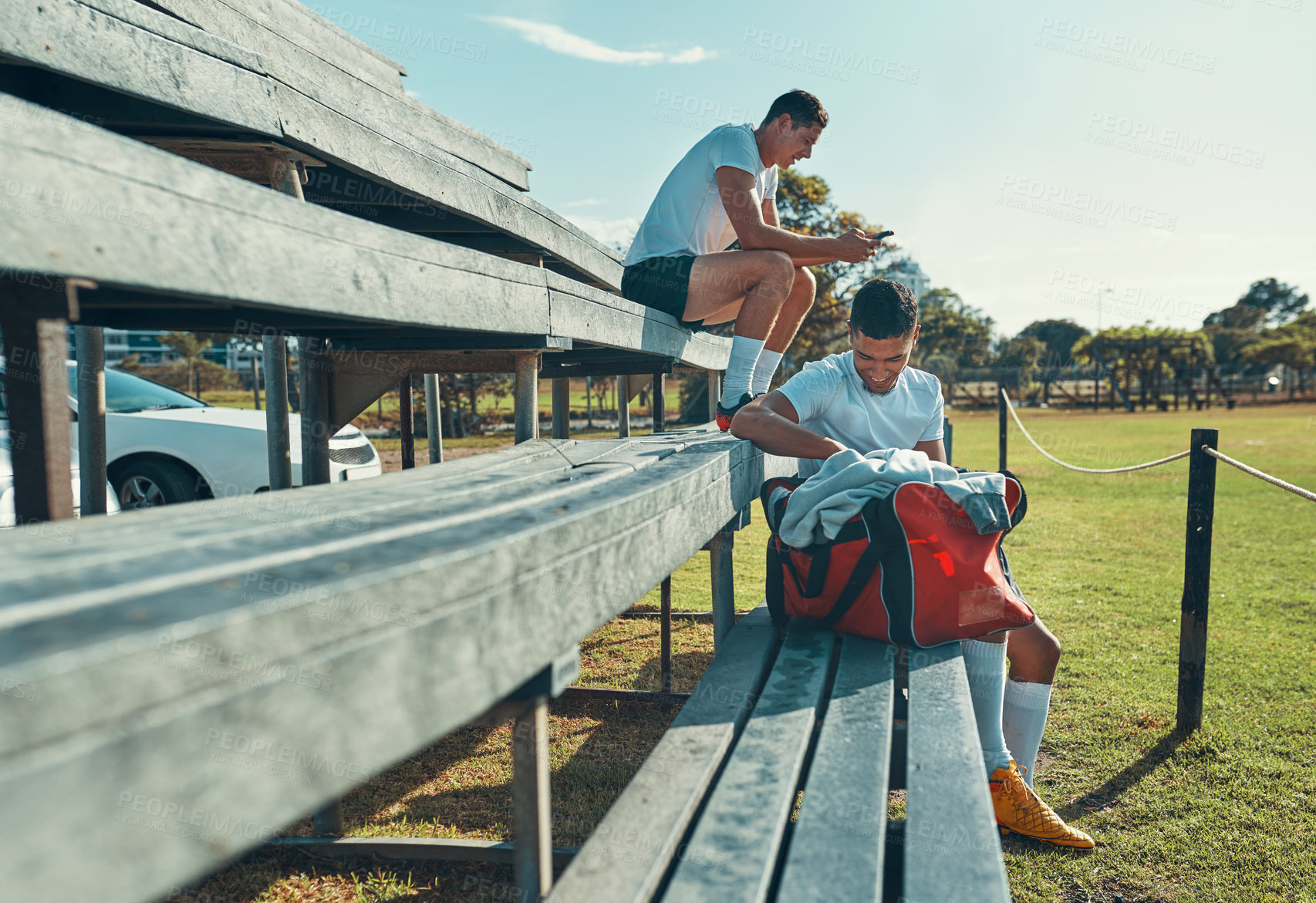 Buy stock photo Rugby, players and men on pavilion for sports, practice and development skills with phone, ball and bag. Exercise, fitness and athlete people outdoor for social media, text message and field on bench