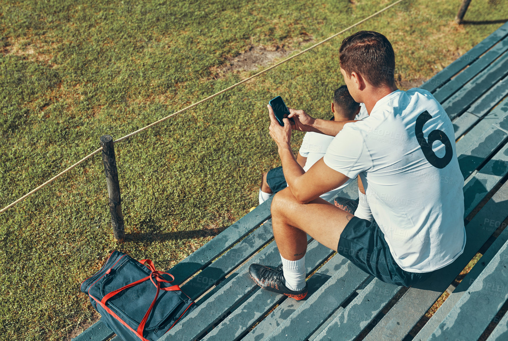 Buy stock photo Sports, soccer and man with phone on field for break from training, workout and practice outdoors. Fitness, bleachers and athlete on smartphone for social media, online text and networking after game