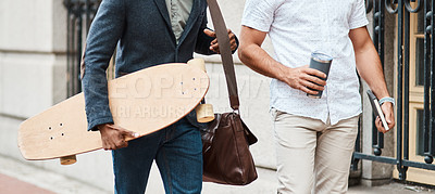 Buy stock photo Cropped shot of two young businessmen walking through the city together