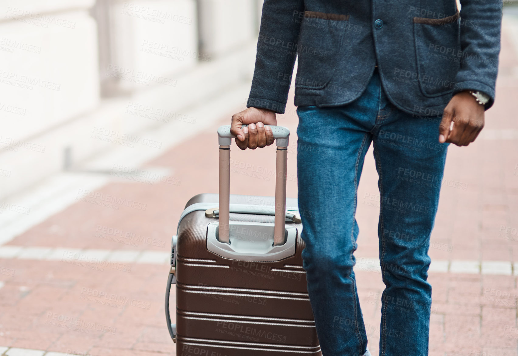 Buy stock photo Shot of an unrecognisable businessman walking through the city with luggage