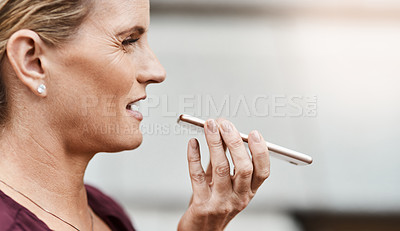 Buy stock photo Shot of a mature businesswoman using a smartphone against an urban background