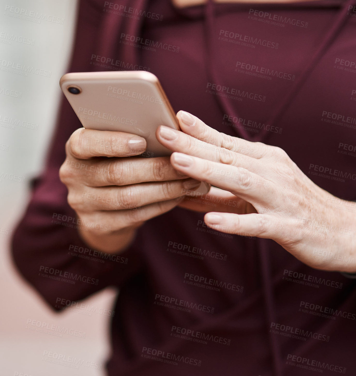 Buy stock photo Cropped shot of an unrecognisable businesswoman using a smartphone against an urban background