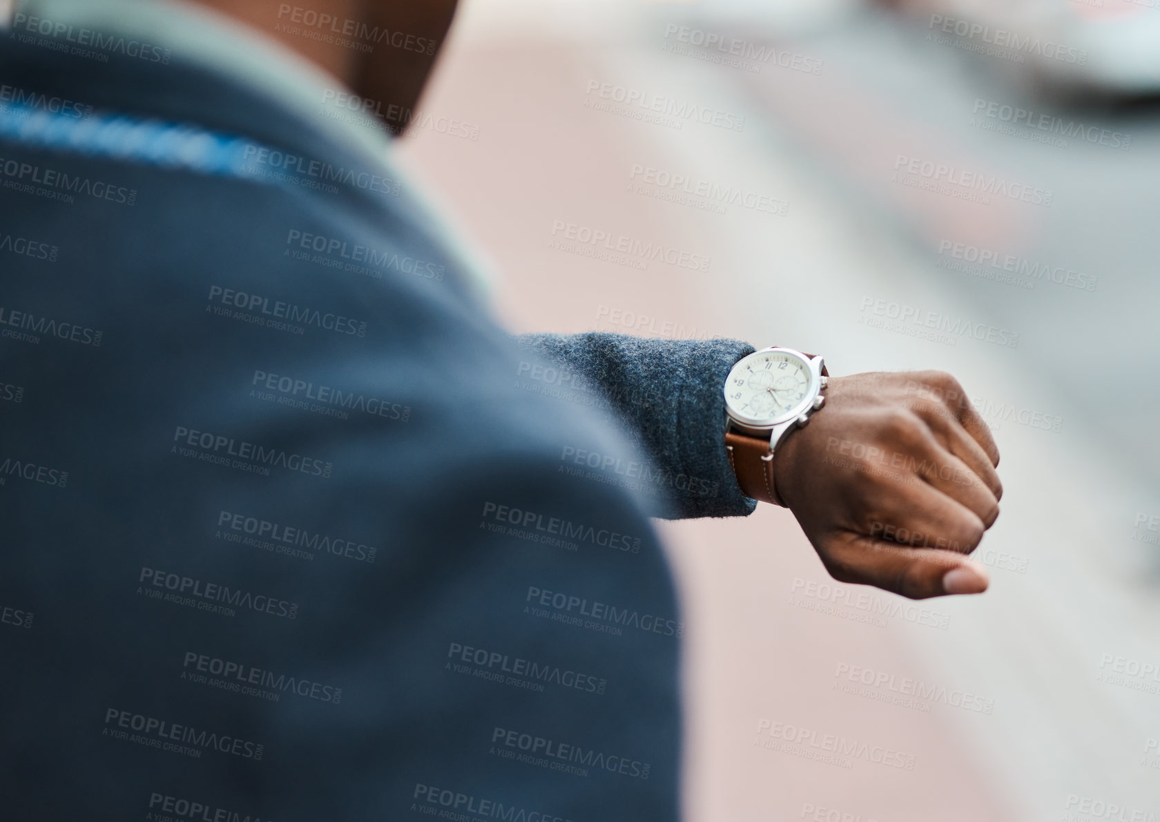 Buy stock photo Cropped shot of a businessman checking the time against an urban background