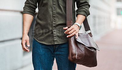 Buy stock photo Cropped shot of an unrecognisable businessman walking through the city