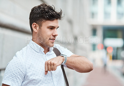 Buy stock photo Chatting on a smartwatch with a young creative business man or intern commuting in the city. Hailing a cab, taxi or ride with an app on wireless technology. Male employee travelling to and from work