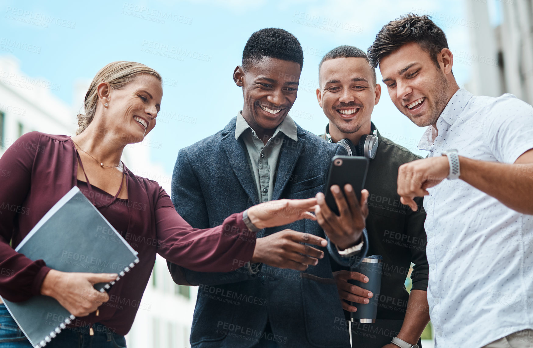 Buy stock photo Young, diverse and creative design team and their manager looking at phone together outside from below. Female leader, boss or CEO showing new staff or interns the company website during orientation