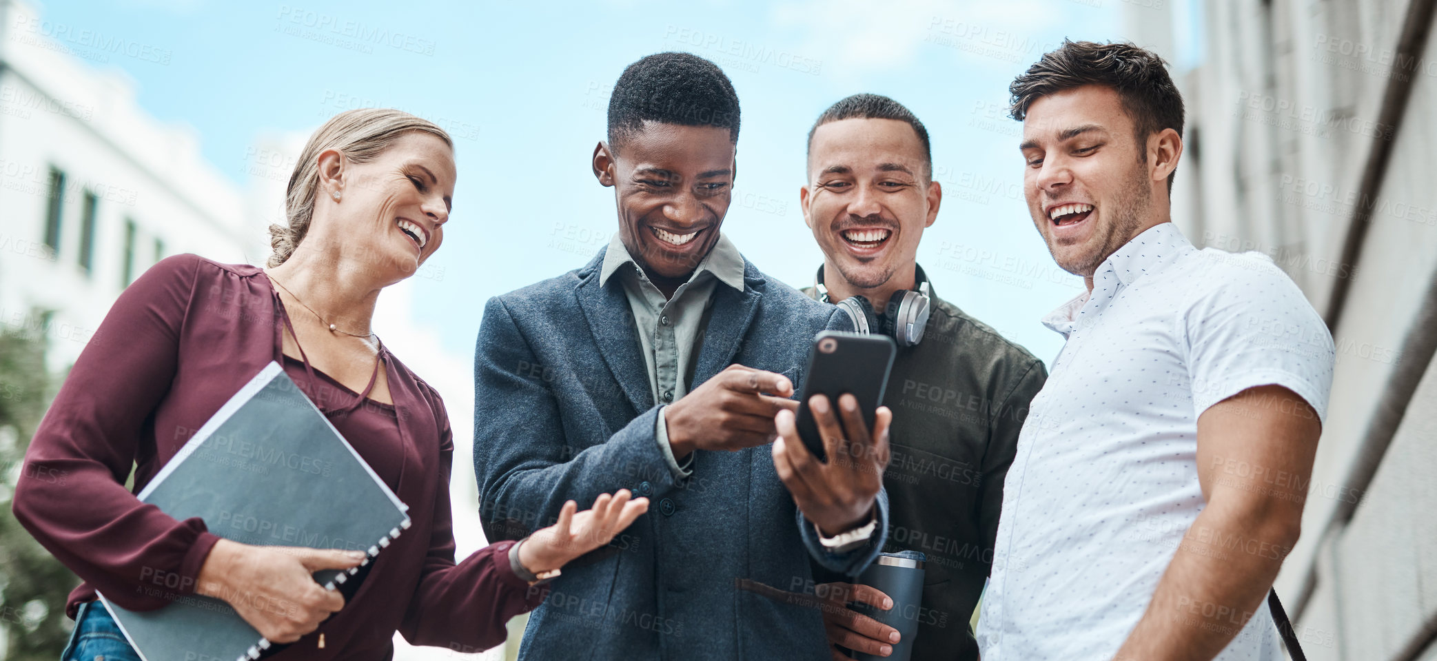 Buy stock photo Shot of a group of businesspeople using a smartphone together against an urban background