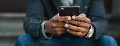 Buy stock photo Cropped shot of a businessman using a smartphone against an urban background