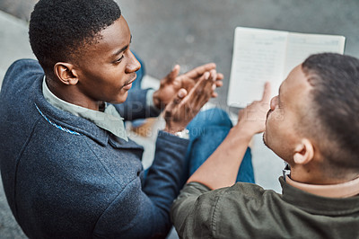 Buy stock photo Shot of two young businessmen having an informal meeting against an urban background