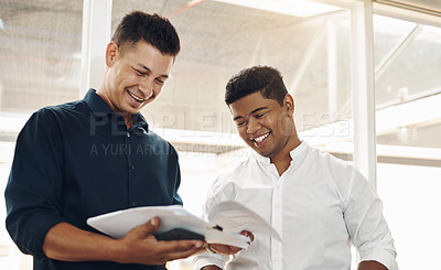 Buy stock photo Cropped shot of two handsome young businessmen looking over their notes after a successful meeting in the boardroom