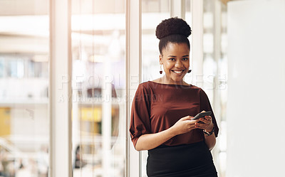 Buy stock photo Cropped portrait of an attractive young businesswoman using her cellphone while standing in the office