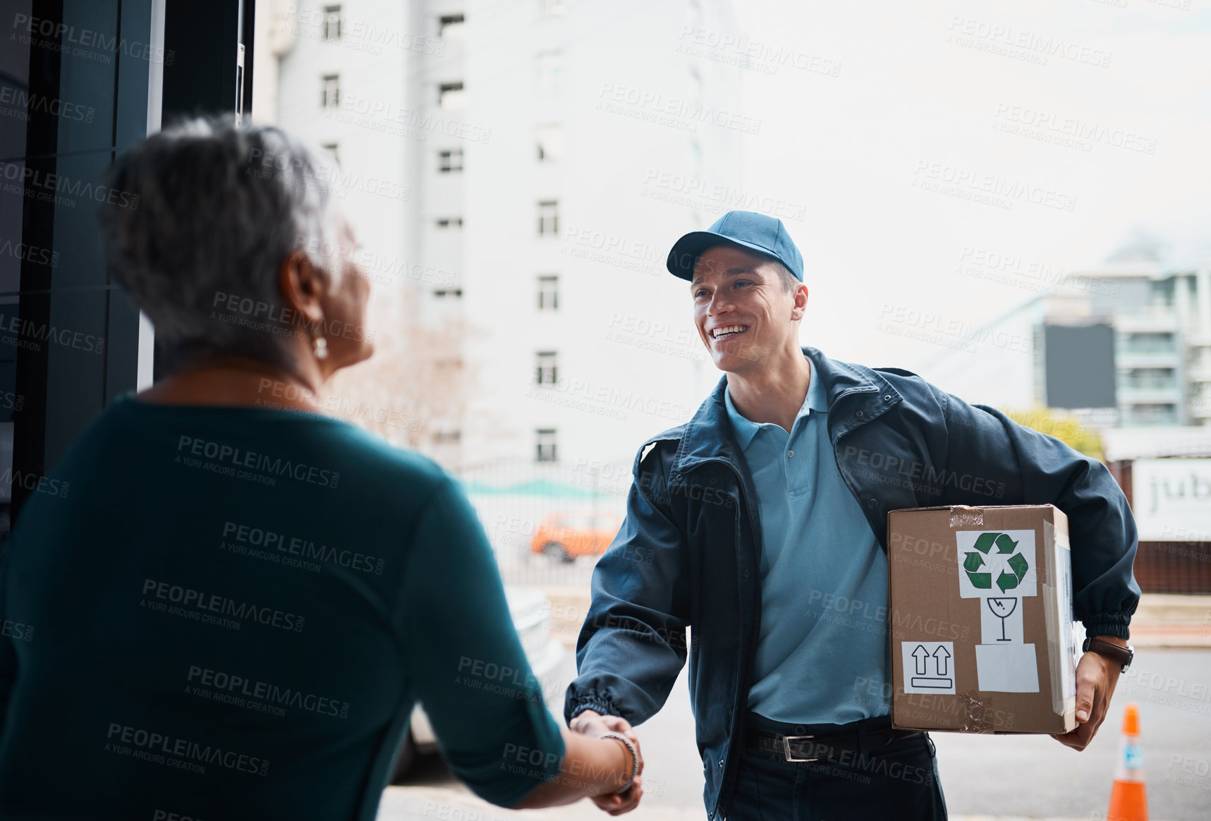 Buy stock photo Cropped shot of a handsome young man delivering a package to a customer