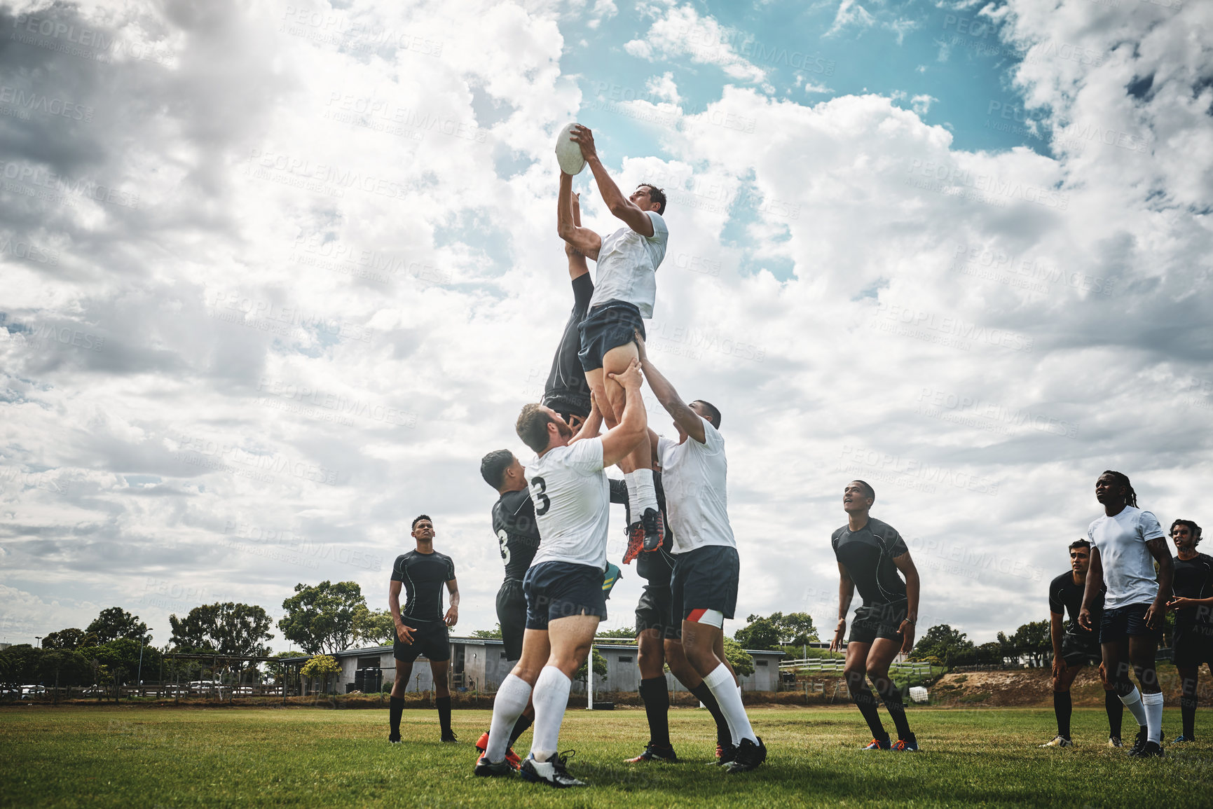 Buy stock photo Shot of two rugby teams competing over a ball during a line out of a rugby match outside on a filed