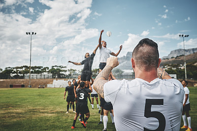 Buy stock photo Rearview shot of two rugby teams competing over a ball during a line out of a rugby match outside on a filed