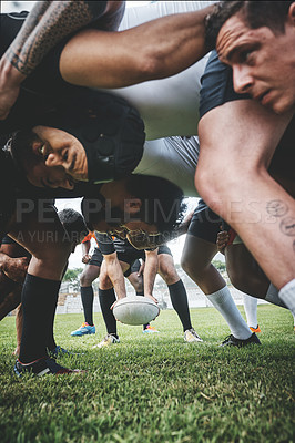 Buy stock photo Low angle shot of two young rugby teams competing in a scrum during a rugby match on a field