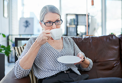 Buy stock photo Shot of a mature businesswoman drinking tea in an office lounge