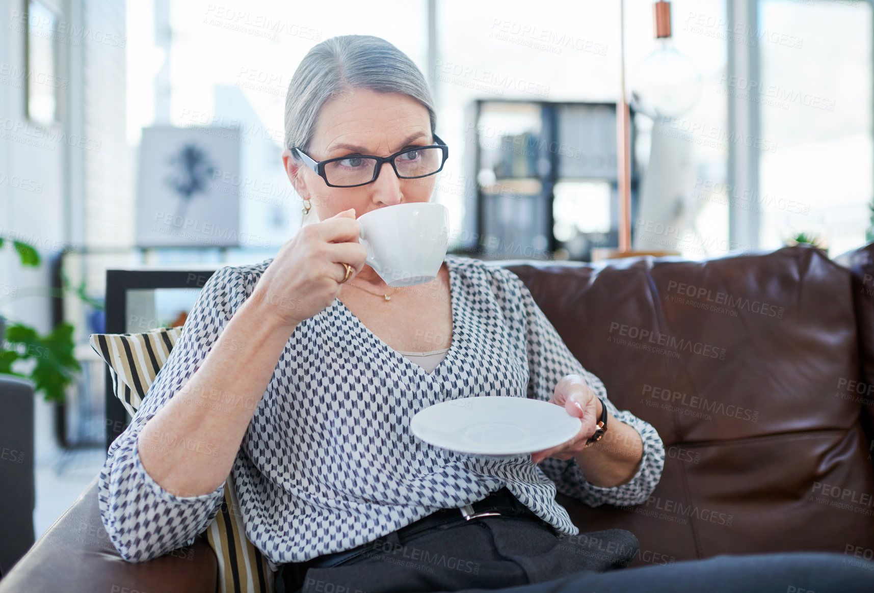 Buy stock photo Shot of a mature businesswoman drinking tea in an office lounge