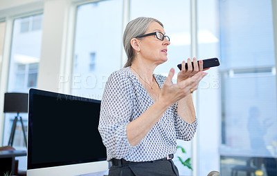 Buy stock photo Shot of a mature businesswoman using a cellphone in an office