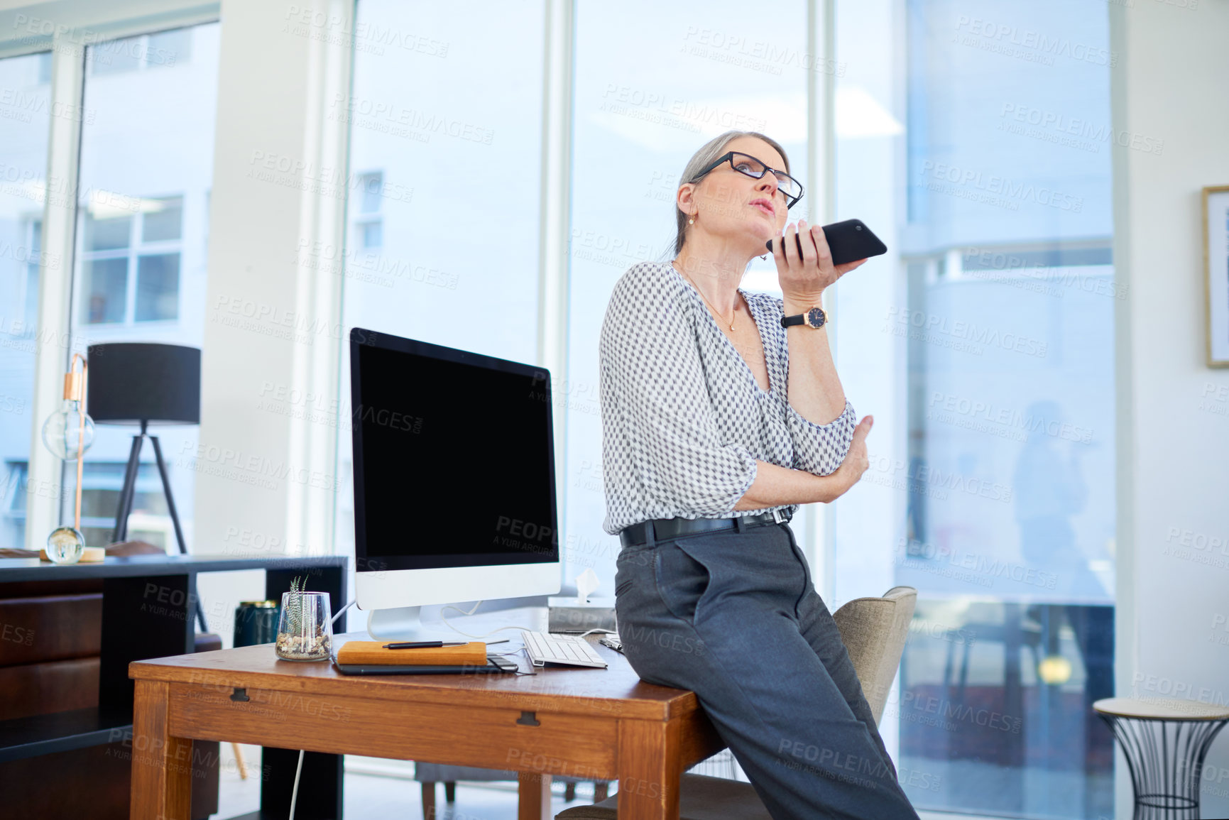 Buy stock photo Shot of a mature businesswoman using a cellphone in an office