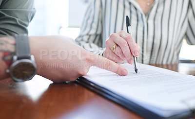 Buy stock photo Closeup shot of two unrecognisable businesspeople going through paperwork together in an office
