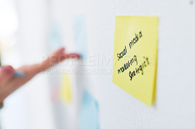 Buy stock photo Closeup shot of an unrecognisable businesswoman brainstorming with notes on a wall in an office