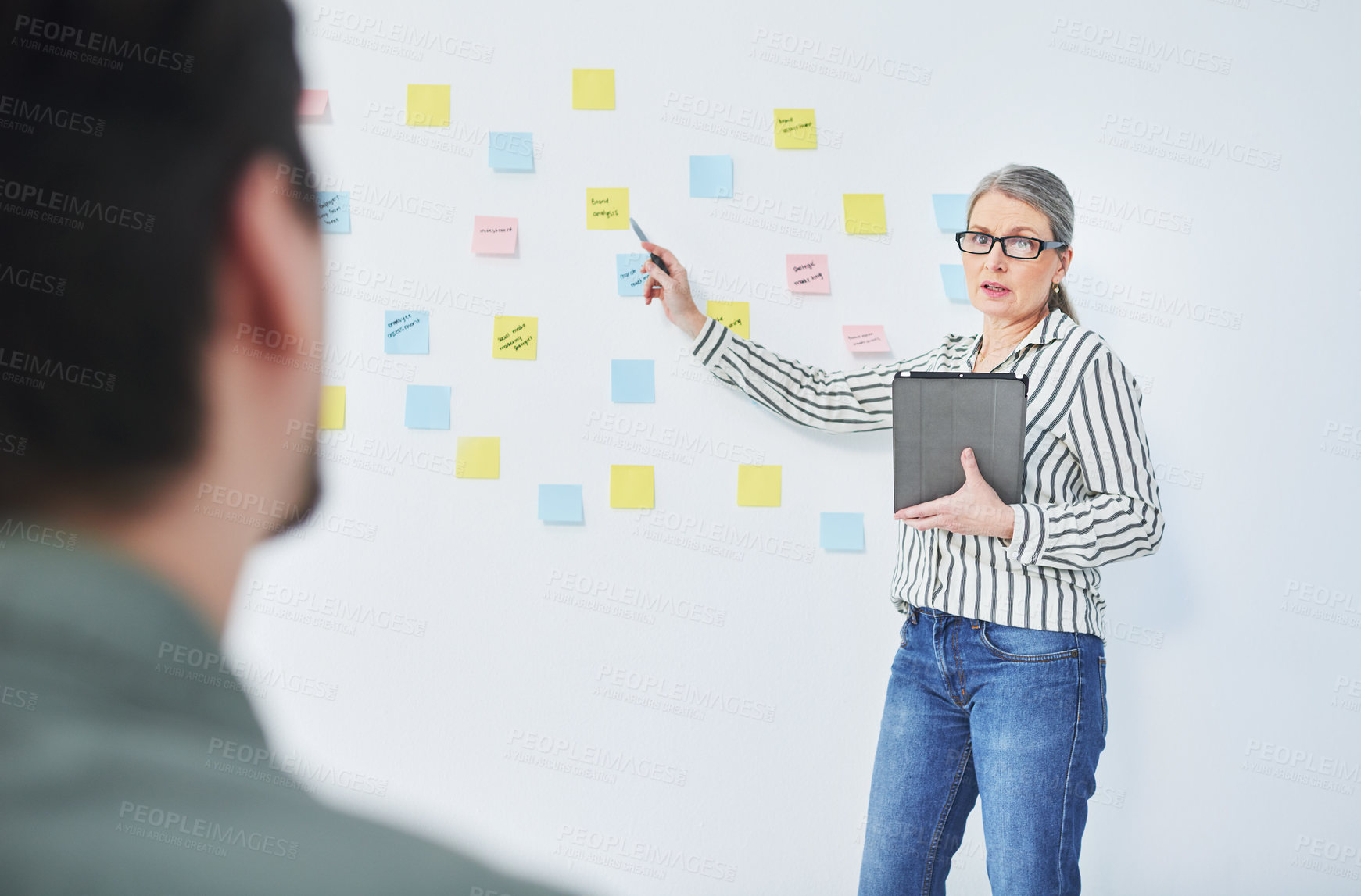 Buy stock photo Shot of a mature businesswoman giving a presentation with notes on a wall in an office