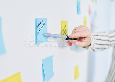 Buy stock photo Closeup shot of an unrecognisable businesswoman brainstorming with notes on a wall in an office