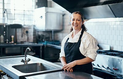 Buy stock photo Portrait of a confident mature woman standing in the kitchen of her cafe