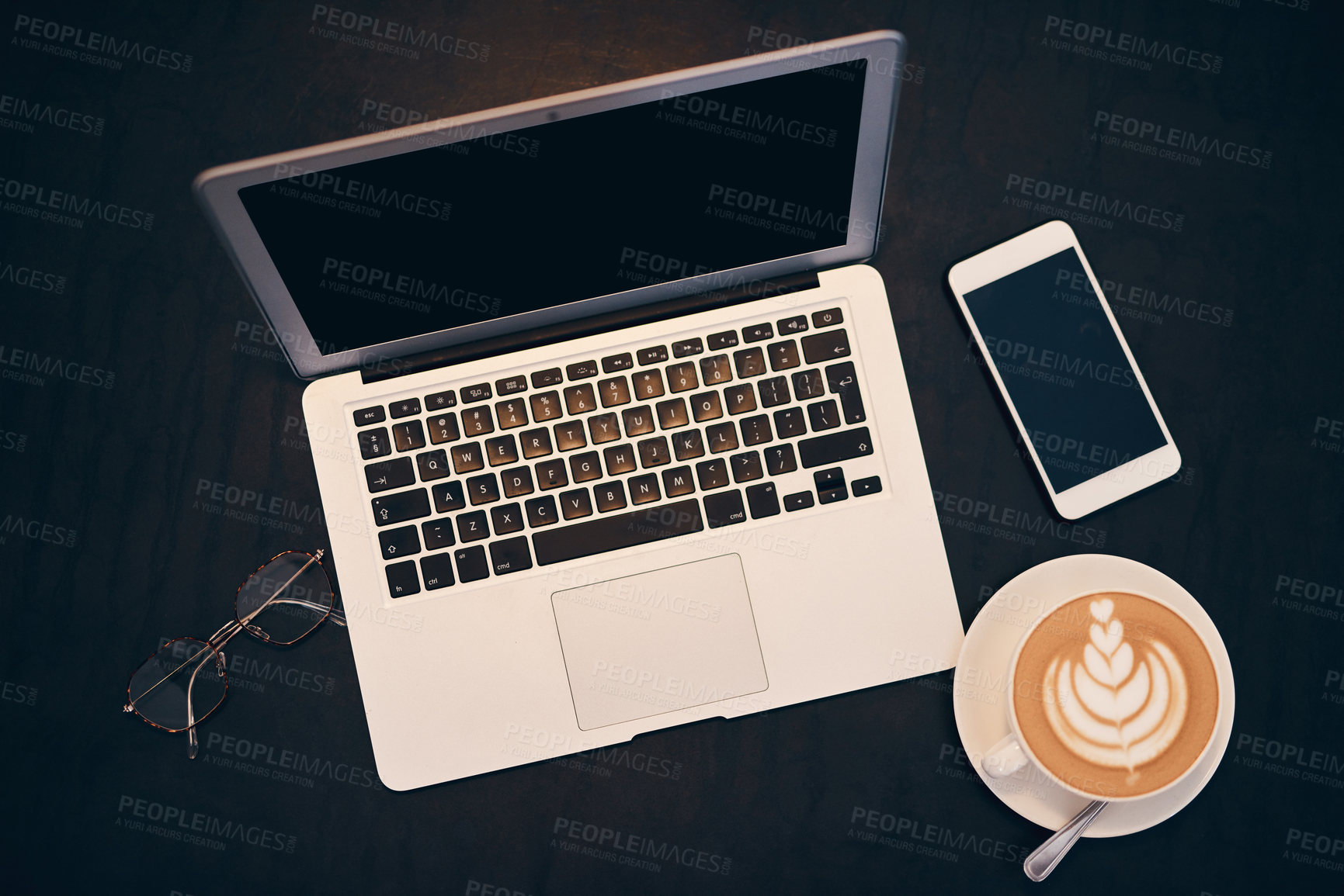Buy stock photo Shot of a laptop, coffee and smartphone on a table in a cafe