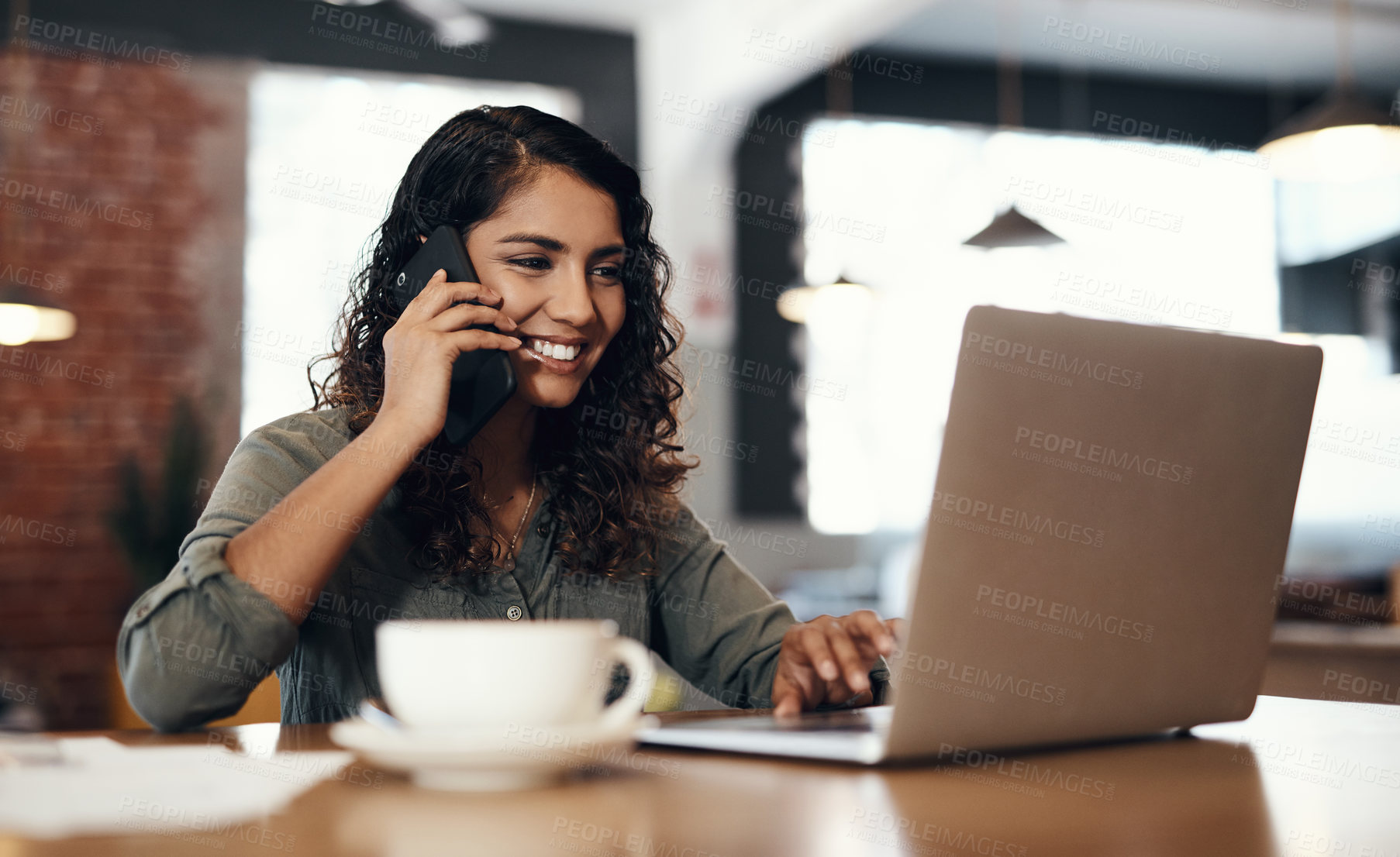 Buy stock photo Freelance, entrepreneur or small business owner talking, networking and plans on a phone call while reading emails on a laptop. Female remote worker in a cafe or coffee shop with wireless technology
