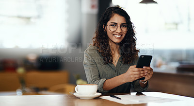 Buy stock photo Shot of a young woman using a smartphone while working in a cafe