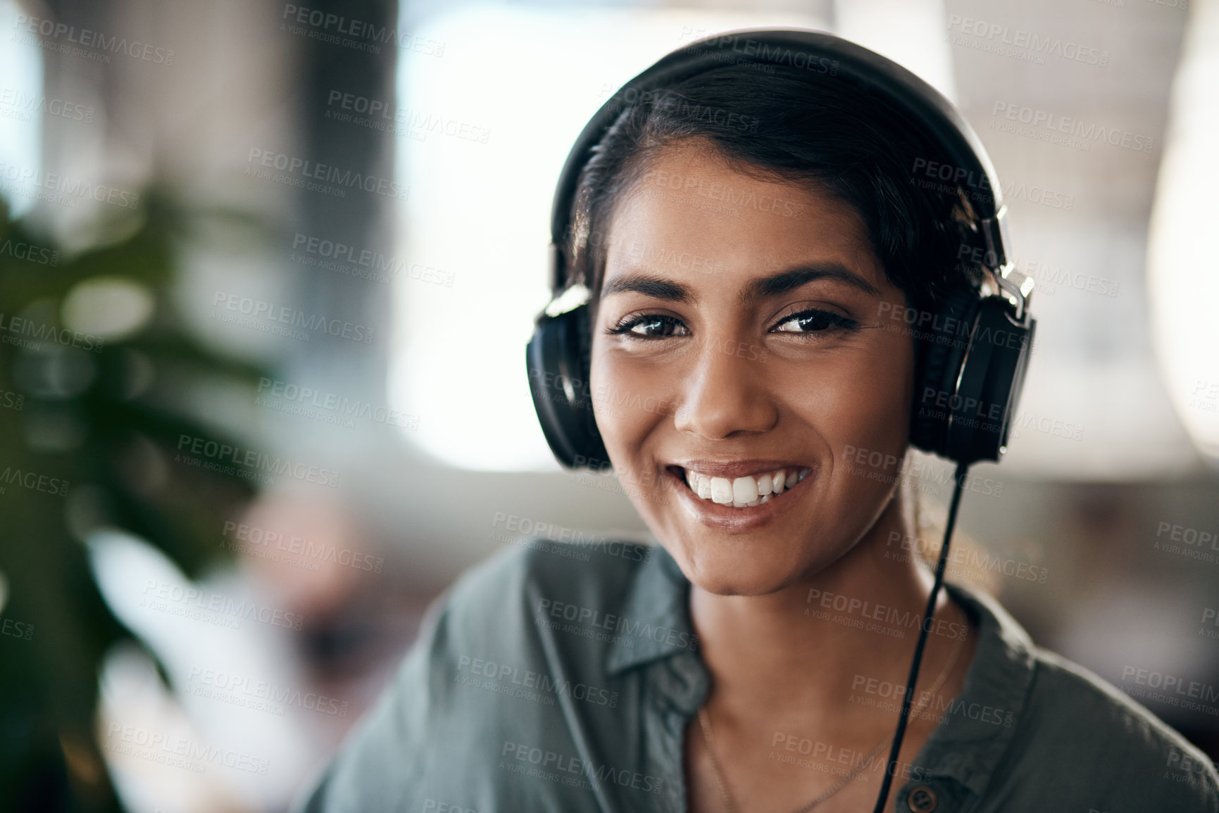 Buy stock photo Shot of a young woman using headphones in a cafe