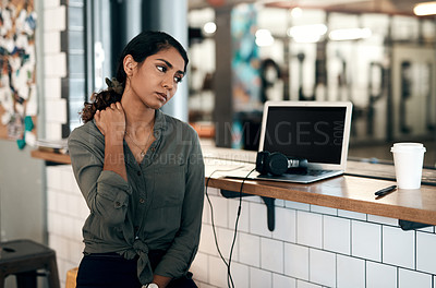 Buy stock photo Shot of a young woman experiencing stress while working in a cafe  