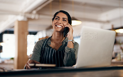 Buy stock photo Shot of a young woman using a laptop and smartphone while working in a cafe