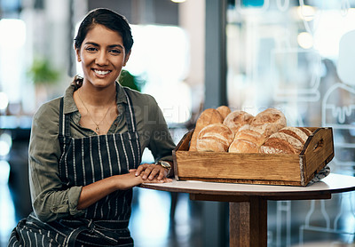 Buy stock photo Portrait of a female restaurant waiter, baker or coffee shop retail manager with fresh bread for breakfast. Smiling, happy and young woman bakery worker ready to welcome a customer and work in a cafe