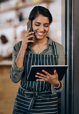 Buy stock photo Shot of a young woman using a digital tablet and smartphone while working in cafe