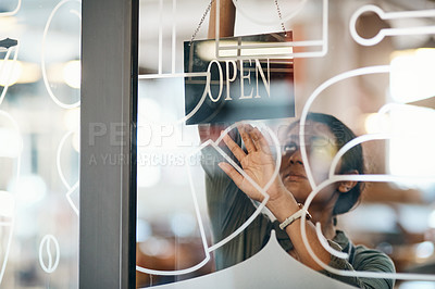 Buy stock photo Shot of a young woman hanging up an open sign on the door of a cafe