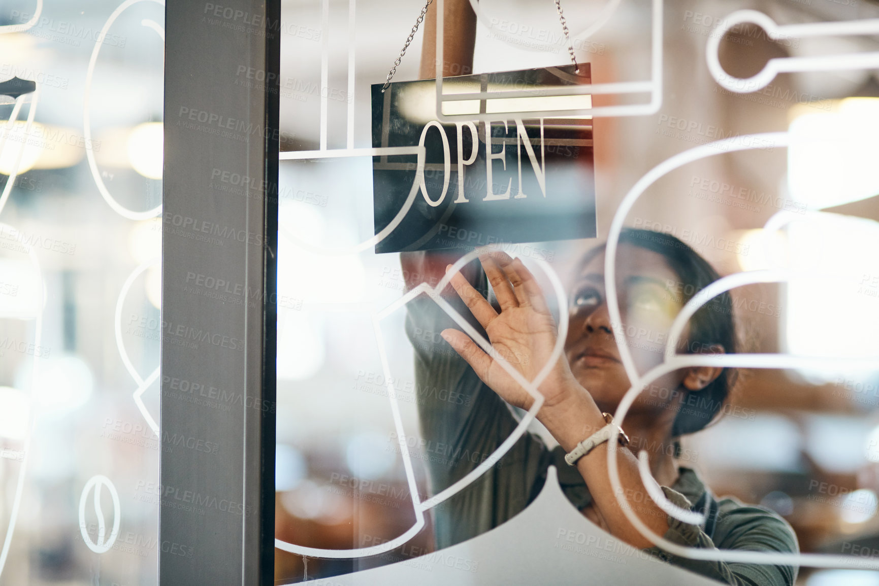 Buy stock photo Shot of a young woman hanging up an open sign on the door of a cafe